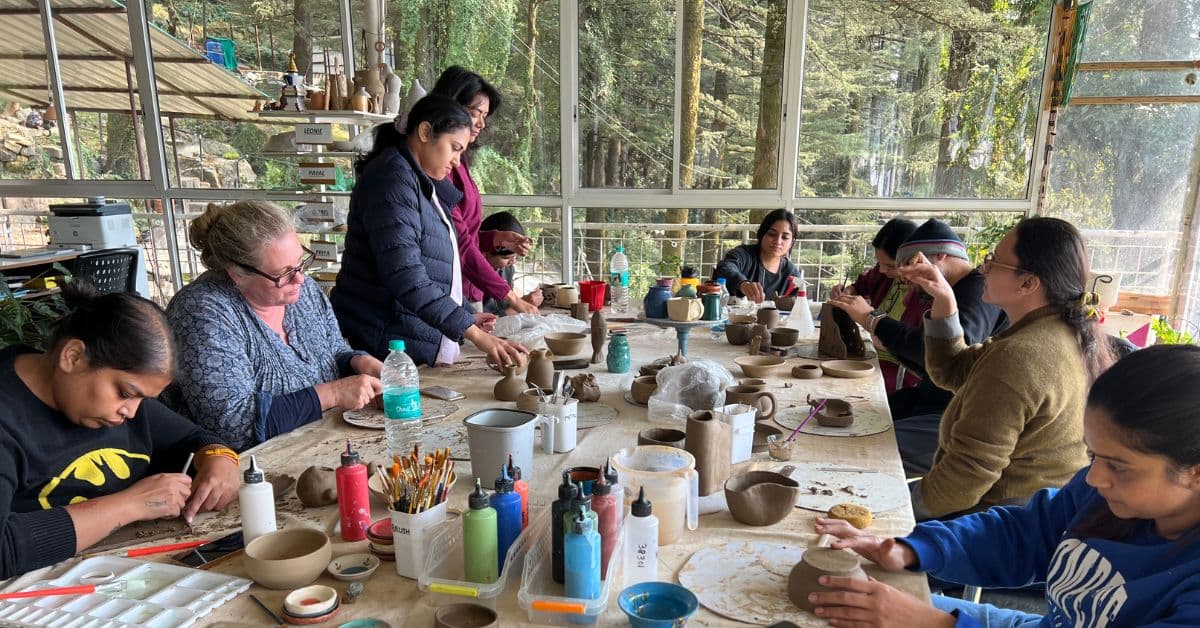 People working with clay in pottery retreat at Dharamkot Studio.