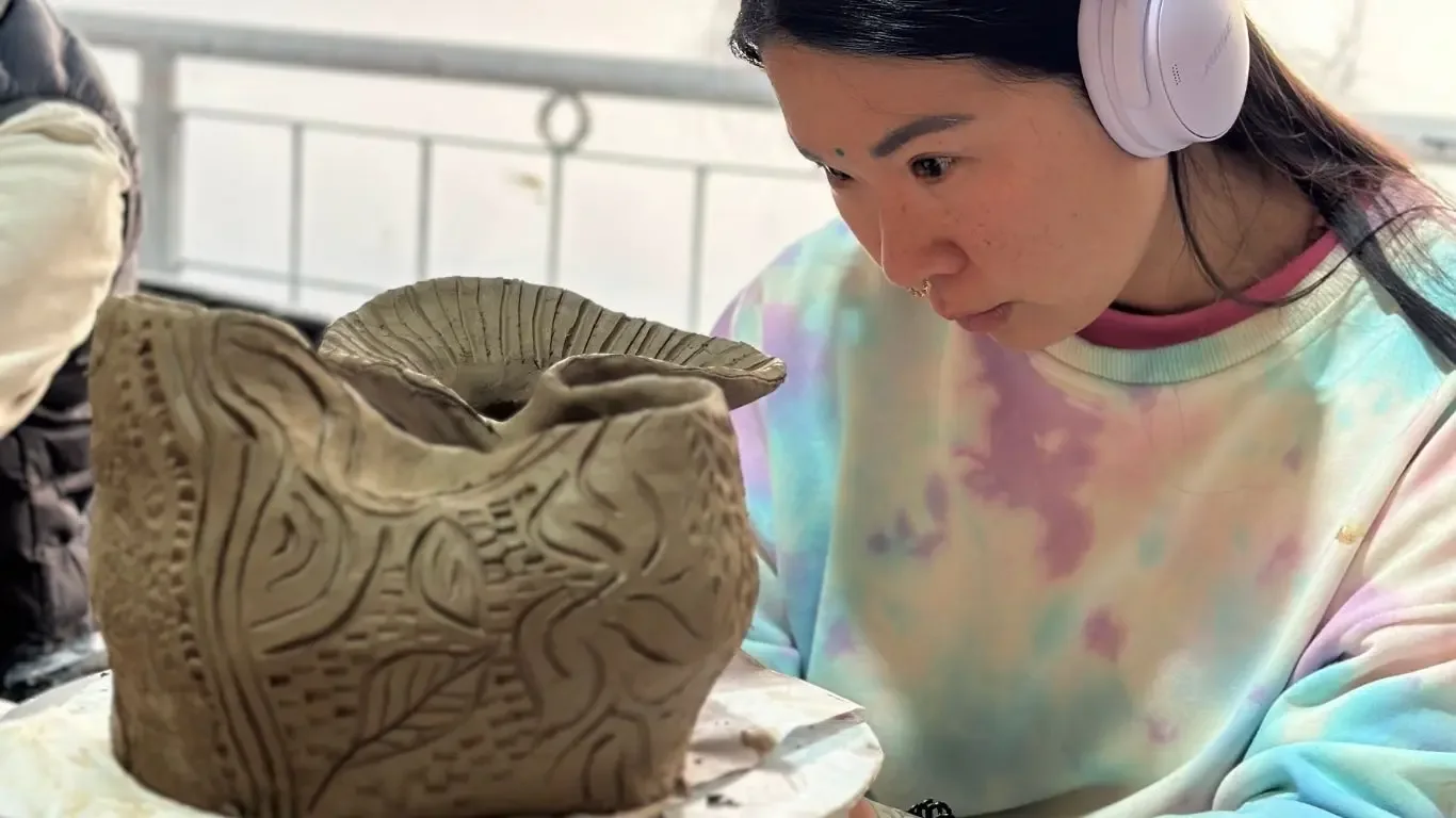 A beginner course student presenting clay work from the section Clay from earth to hands.