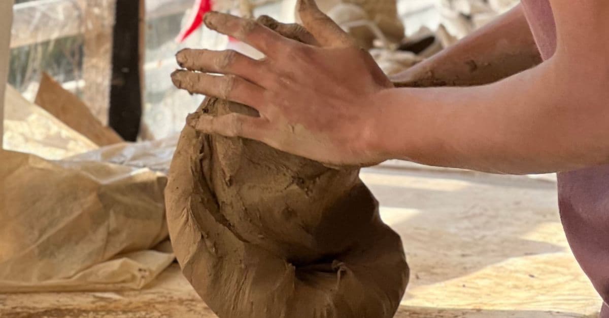 Hands practicing with clay at Dharamkot Studio.