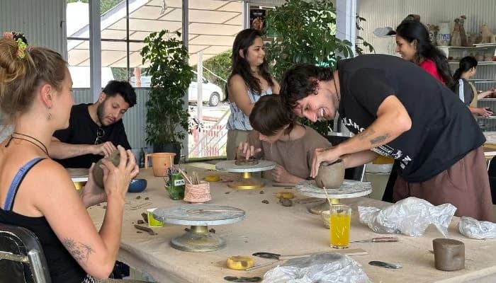 Group pottery workshop at creative retreat in India with participants handbuilding clay.