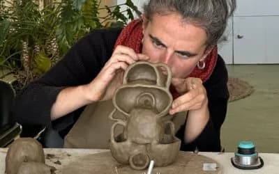 Woman carefully handbuilding clay sculpture at slow living pottery retreat in India.