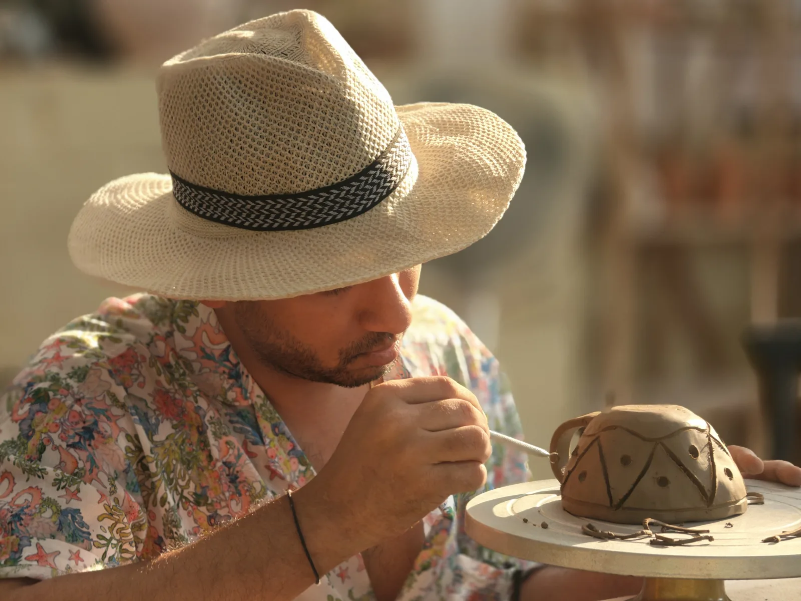 A participant carving details into a handmade ceramic form.