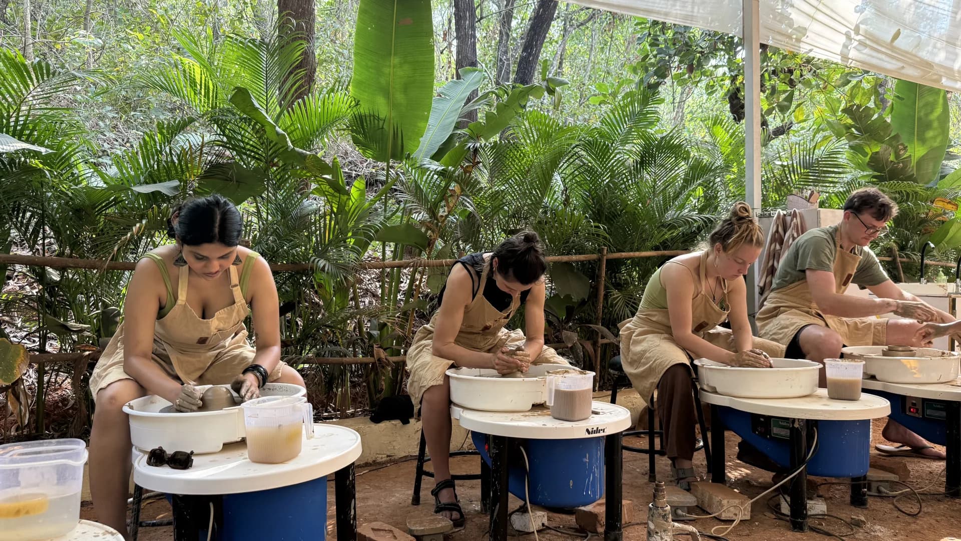 Participants practicing pottery at wheels during Dharamkot Studio's Foundation in Ceramics course.