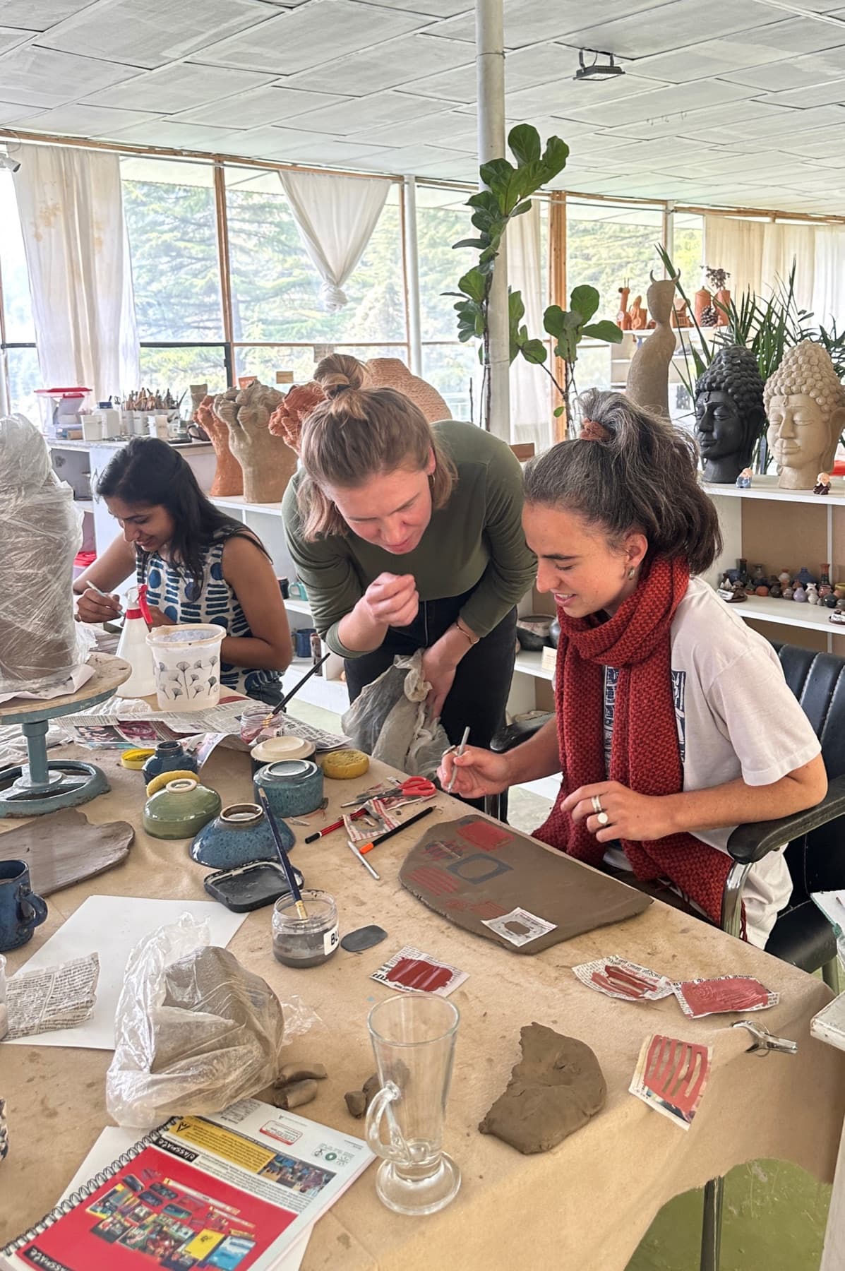 Pottery course students decorating clay work at Dharamkot Studio.