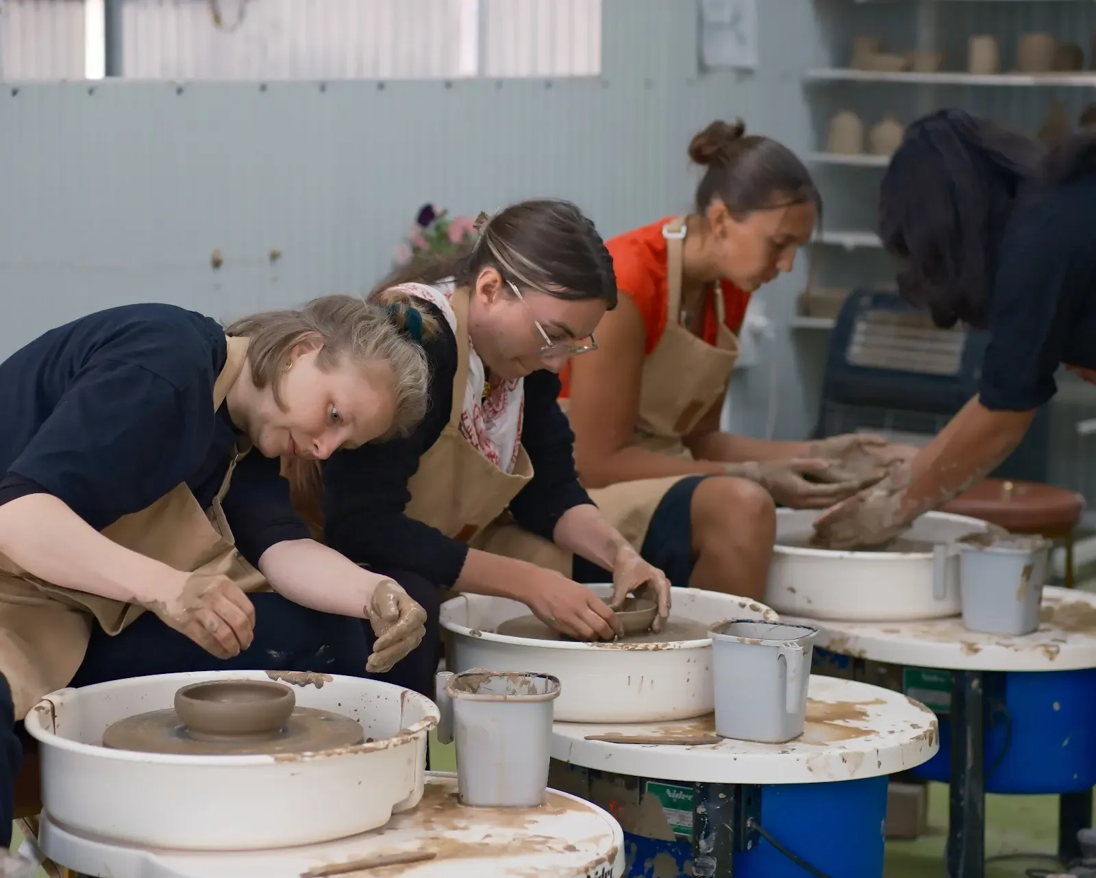 Students and visitors making pottery inside Dharamkot Studio's community art space.