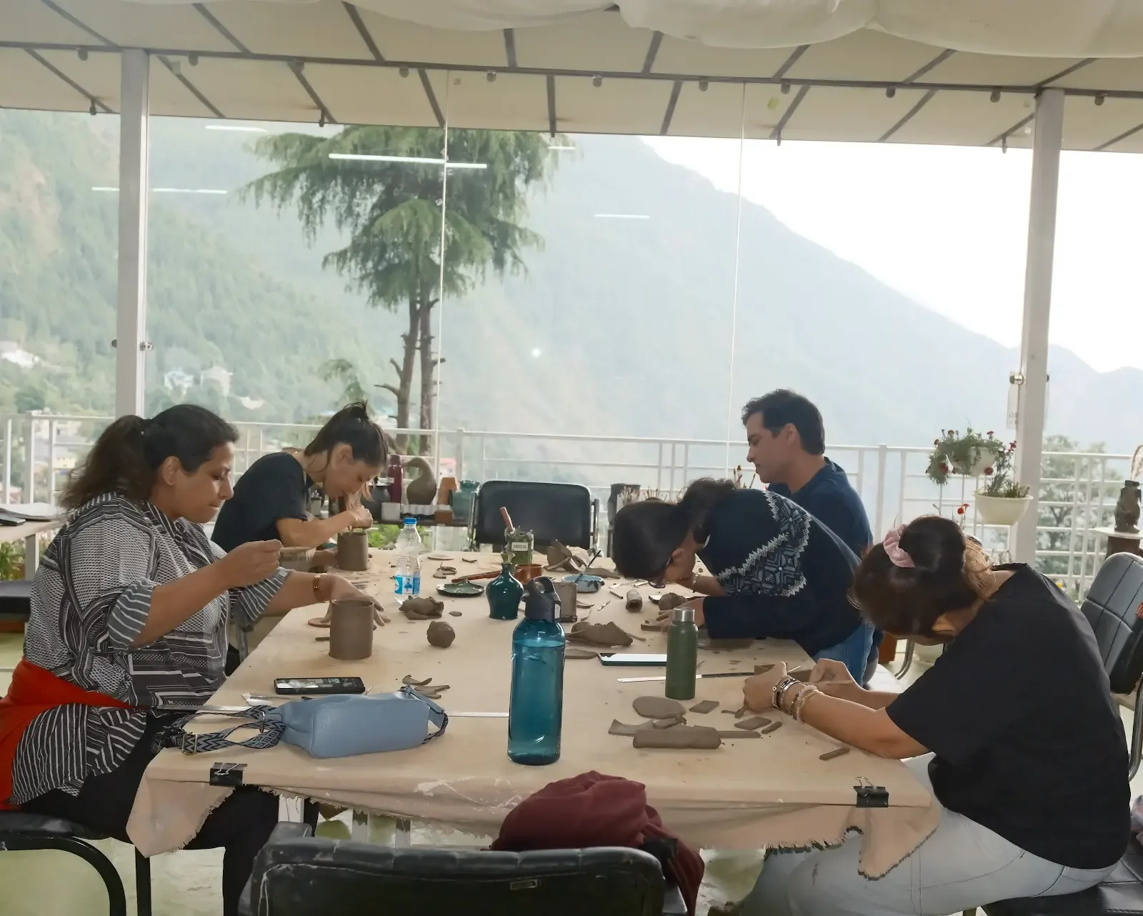 Students and visitors making pottery inside Dharamkot Studio's community art space.