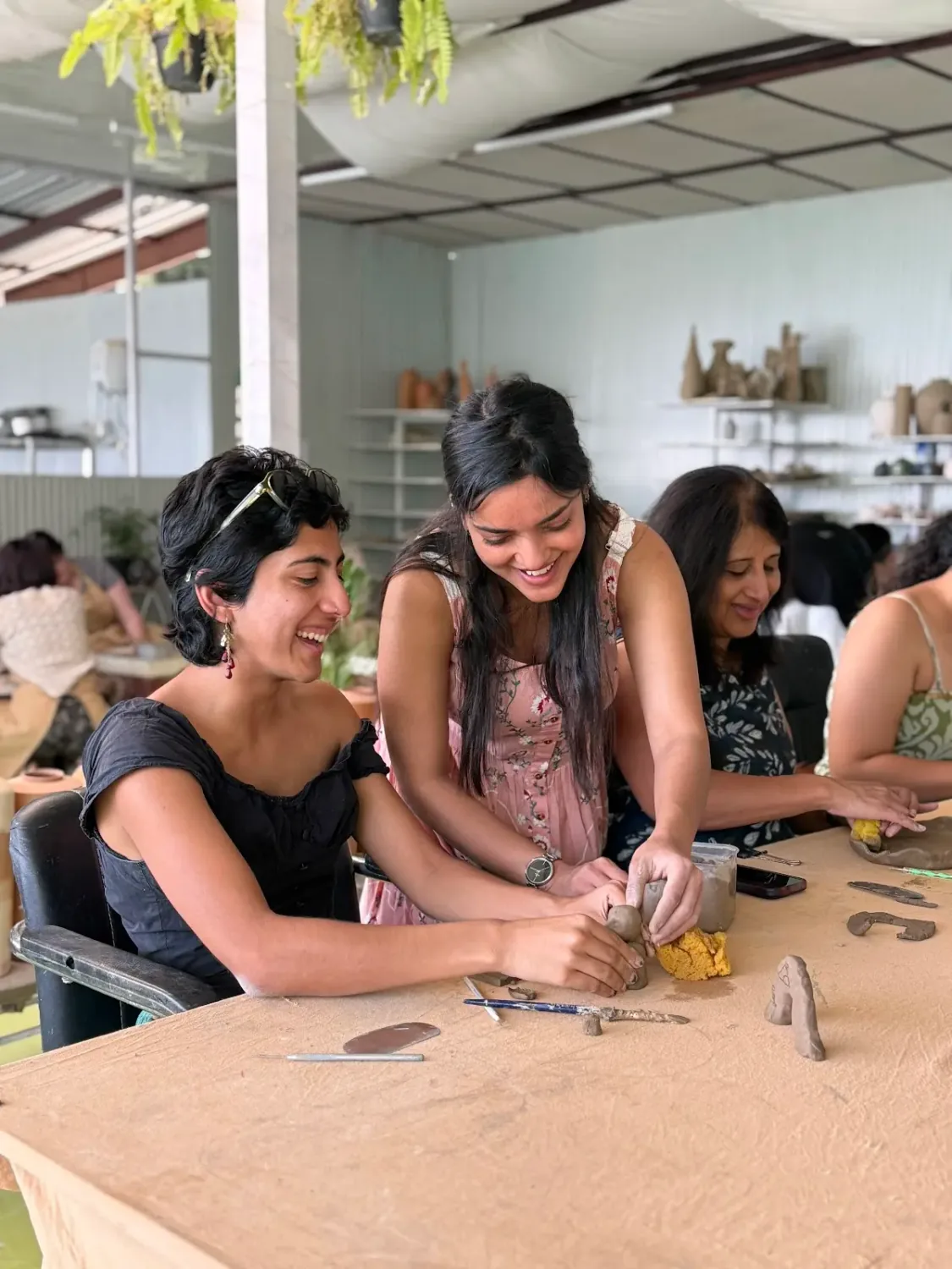 Students and visitors making pottery inside Dharamkot Studio's community art space.