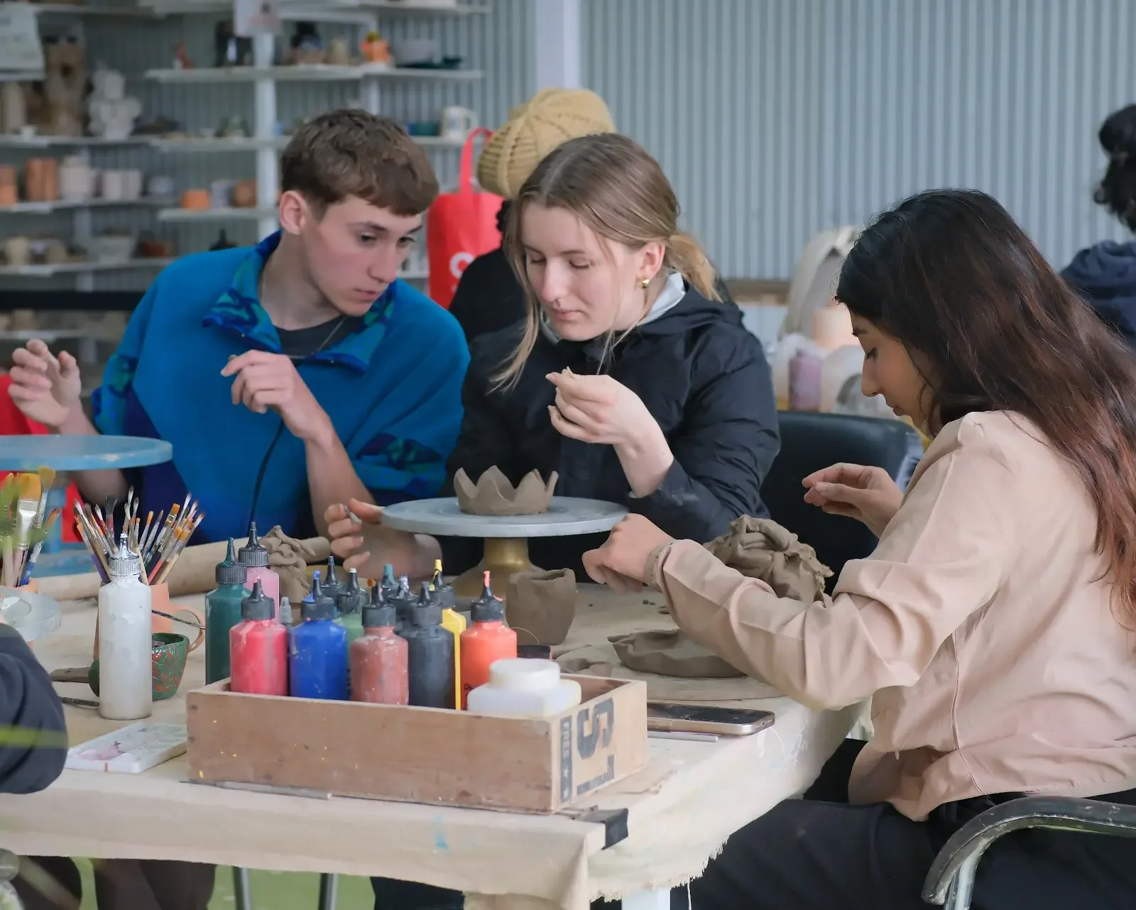 Students and visitors making pottery inside Dharamkot Studio's community art space.