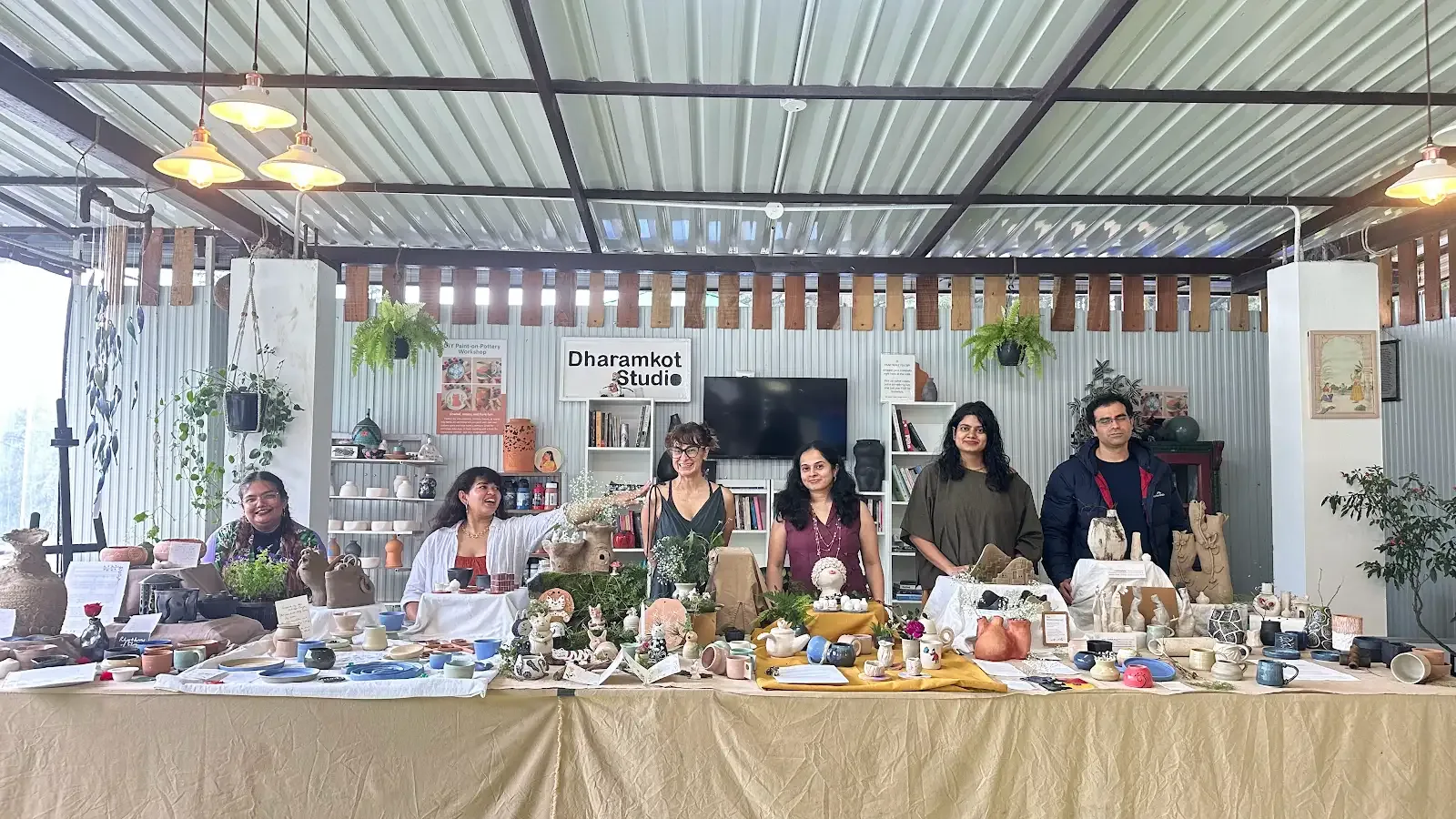 Students and visitors making pottery inside Dharamkot Studio's community art space.