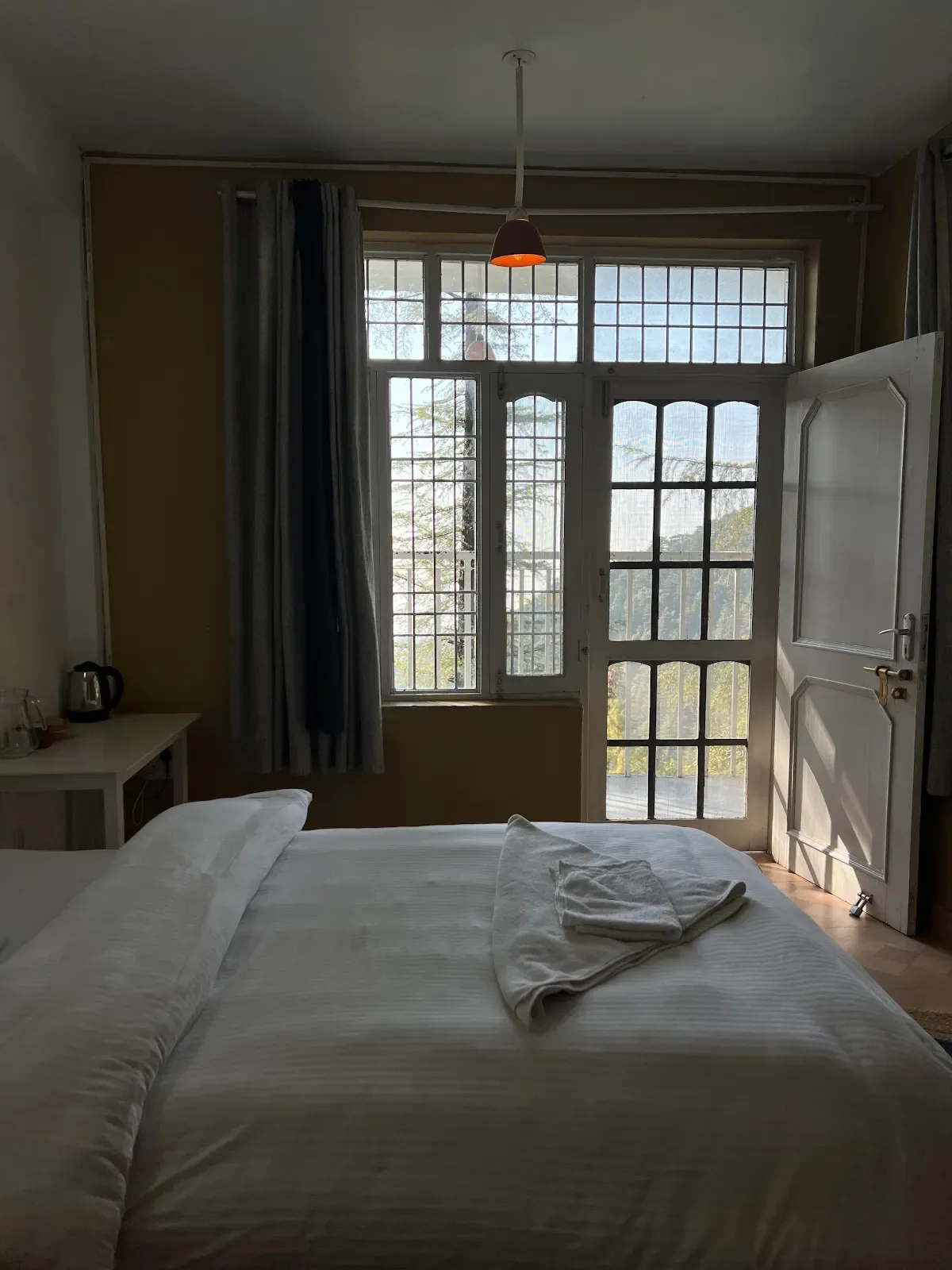 Private retreat room with balcony and mountain light in Dharamkot, Himachal Pradesh.