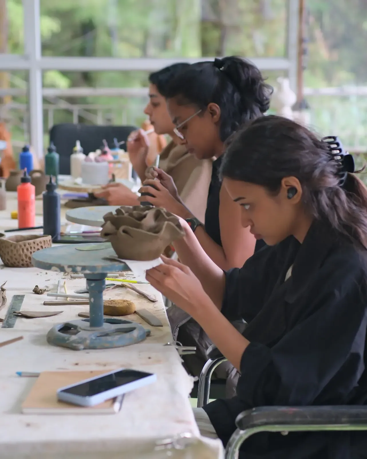 Retreat participant carefully shaping clay during guided pottery practice in Dharamkot.