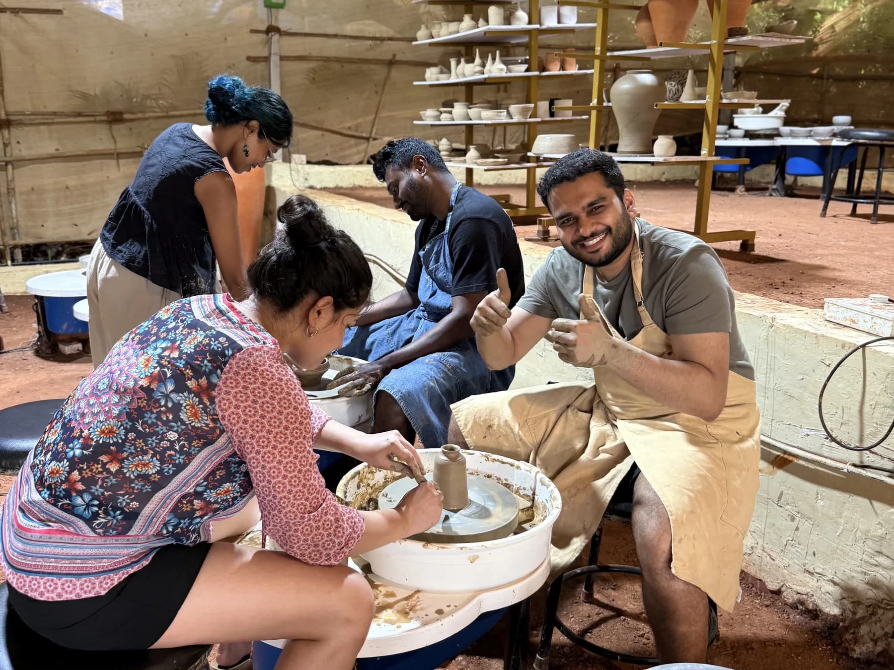Beginner potters practising together at pottery wheels during the Goa retreat.