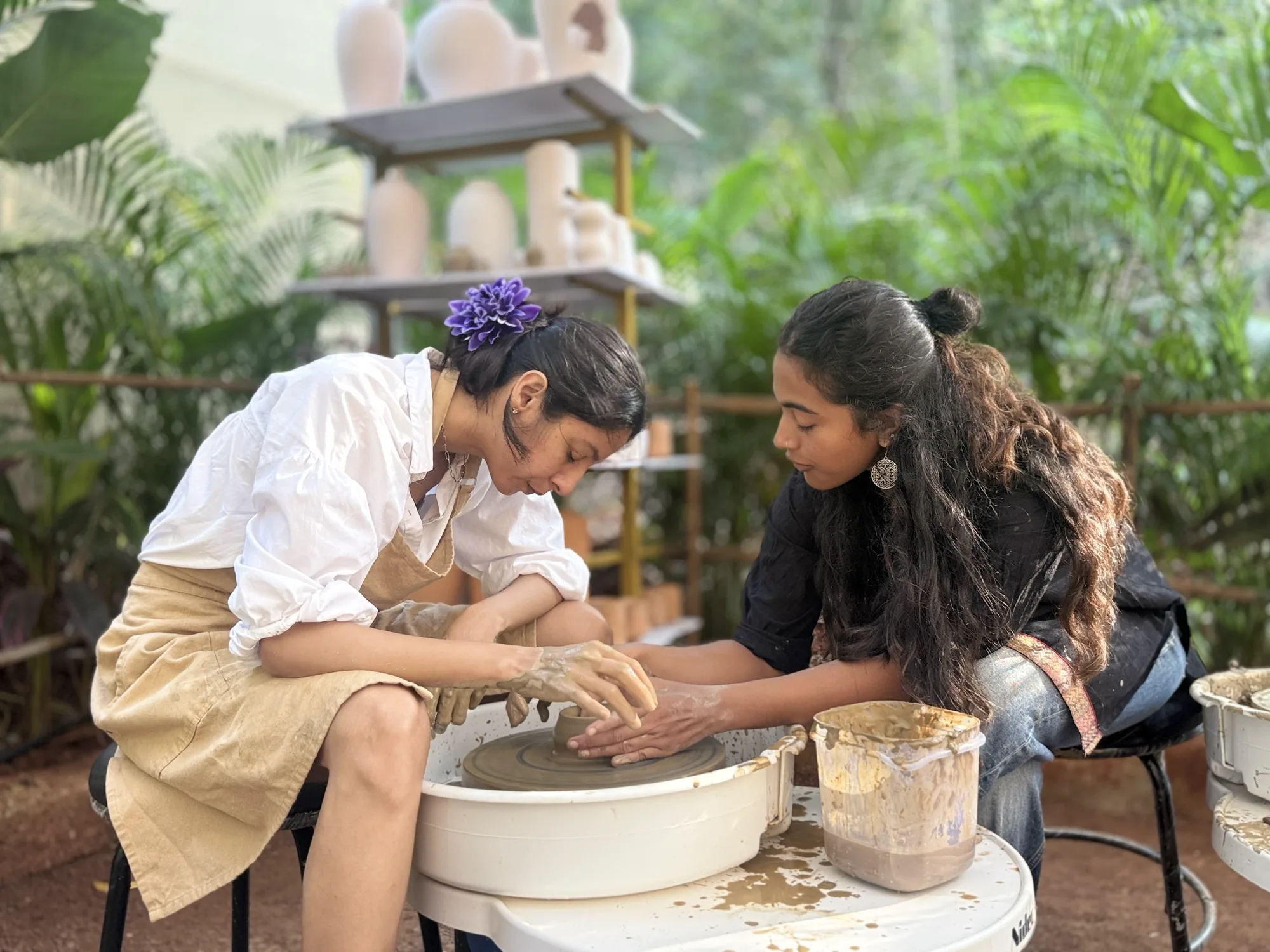 Instructor-guided wheel practice during the Art of Wheel Throwing workshop at Dharamkot Studio in Goa.