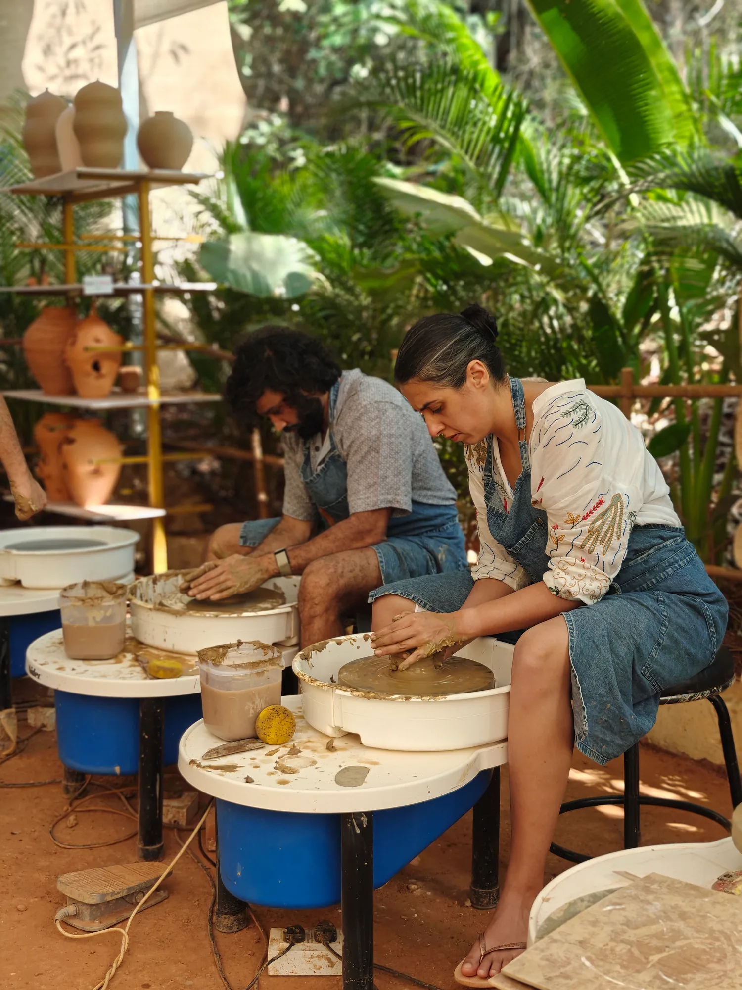 Participants practicing together on pottery wheels in the Goa studio.