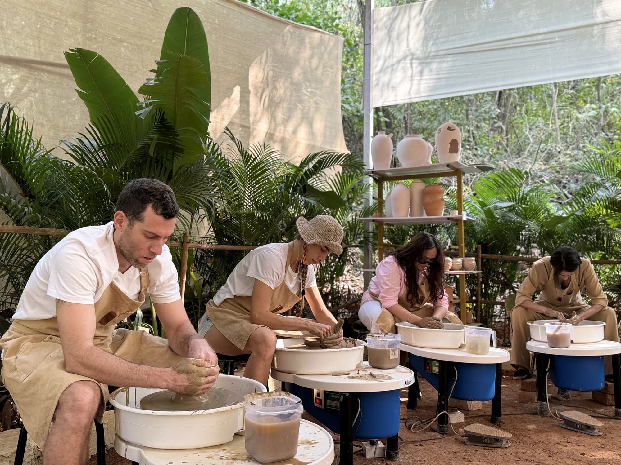 Participants learning the pottery wheel in a guided group session at Dharamkot Studio in Goa.