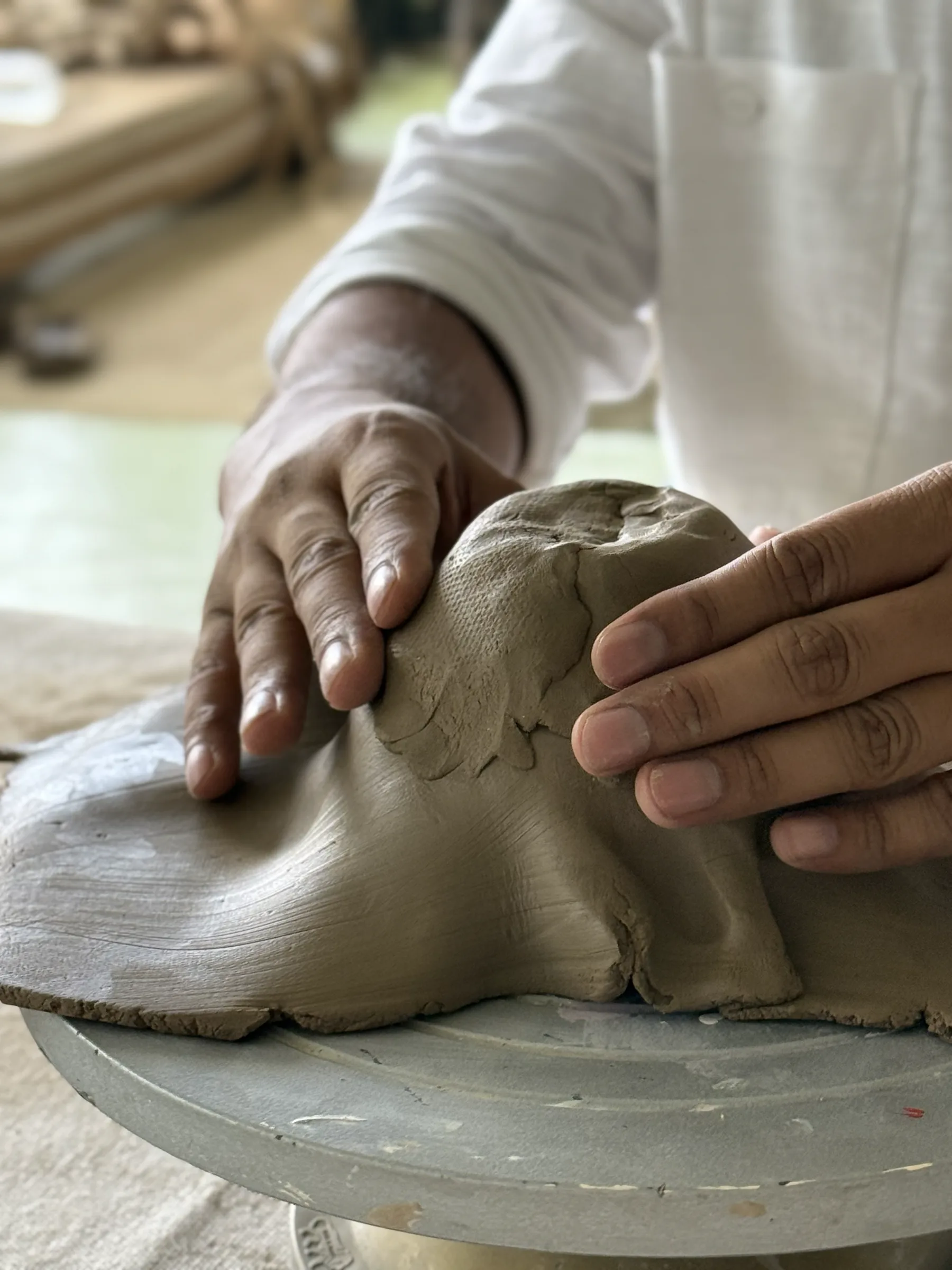 Participants working with clay at a shared table during the Himachal Open Clay Session at Dharamkot Studio.