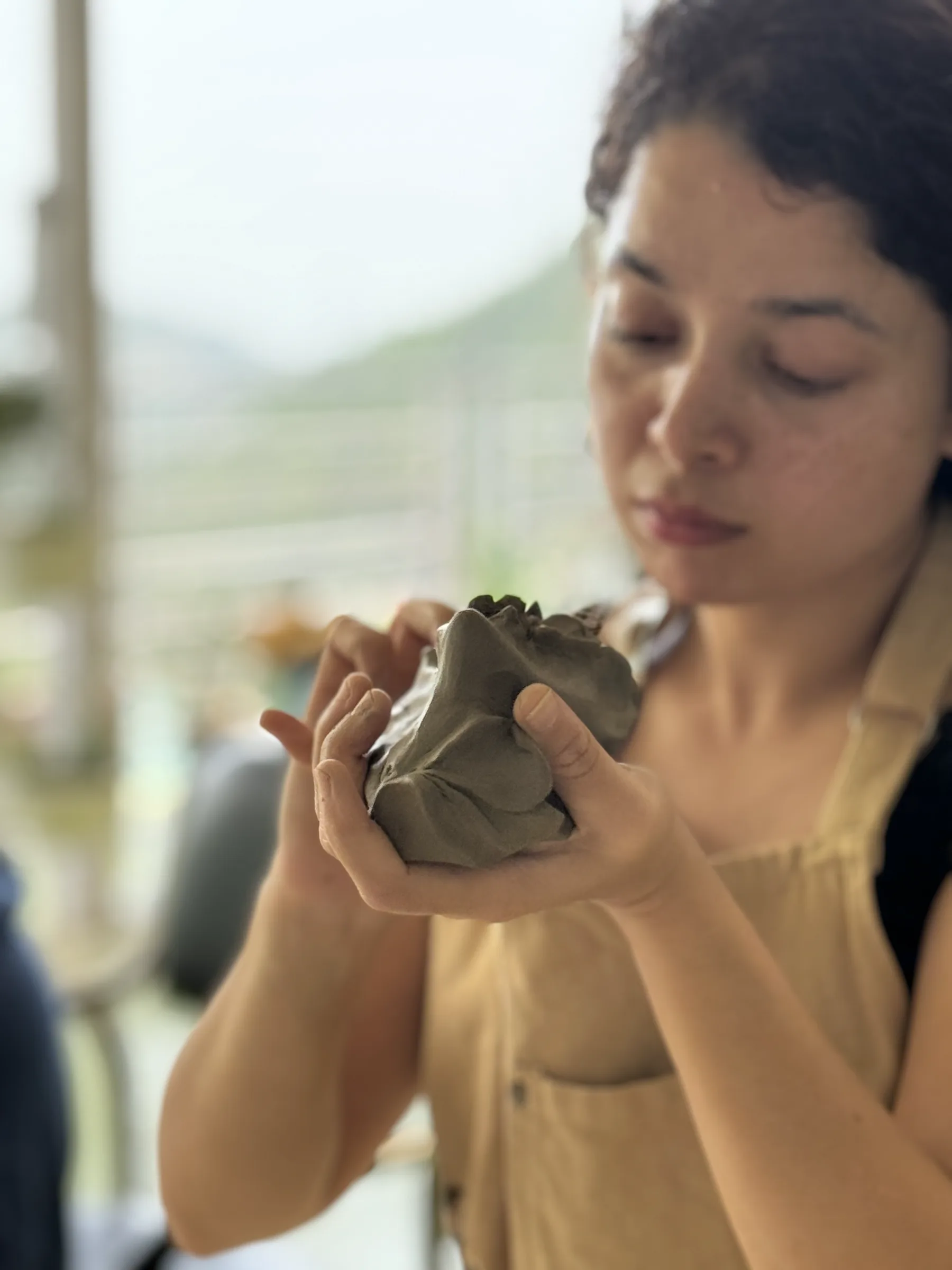 Participant closely shaping a small clay form during the Open Clay Session at Dharamkot Studio.