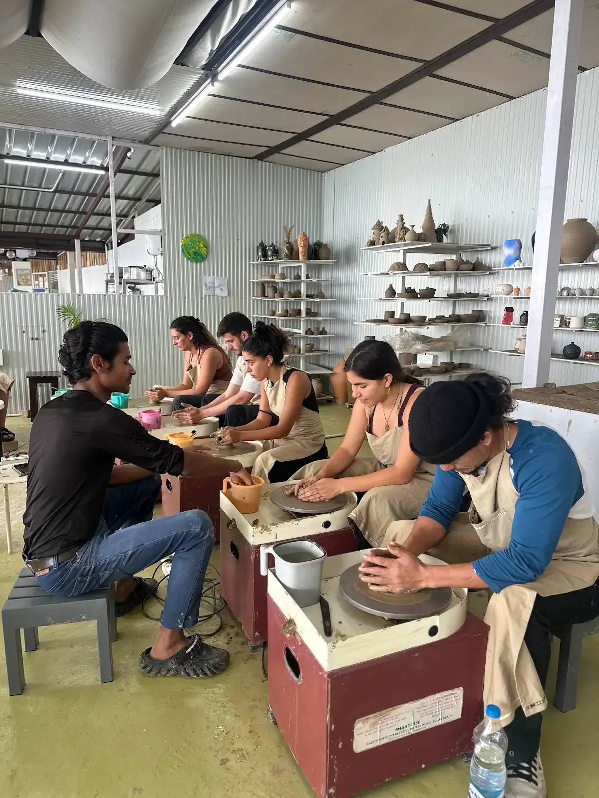 Instructor guiding a beginner pottery wheel class at Dharamkot Studio in Himachal Pradesh.