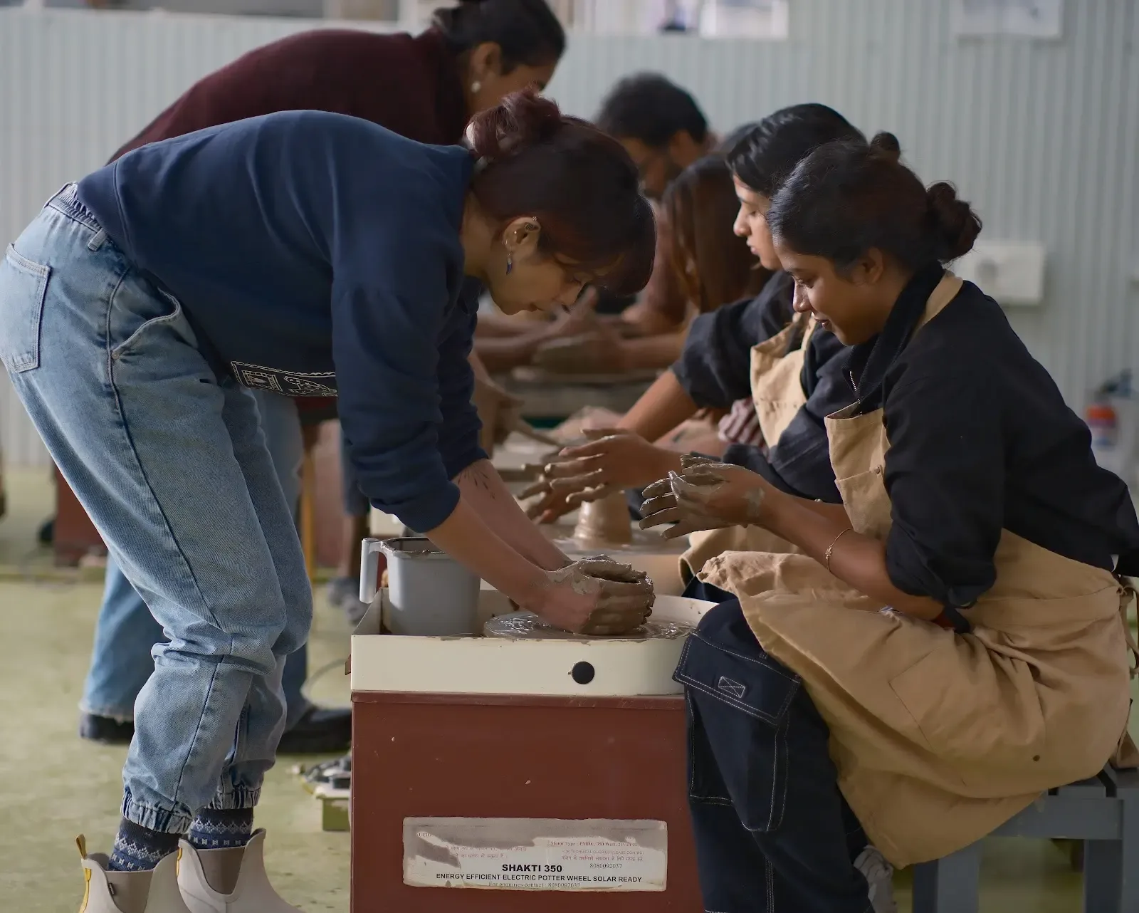 Instructor-led group pottery wheel class at Dharamkot Studio in Himachal Pradesh.