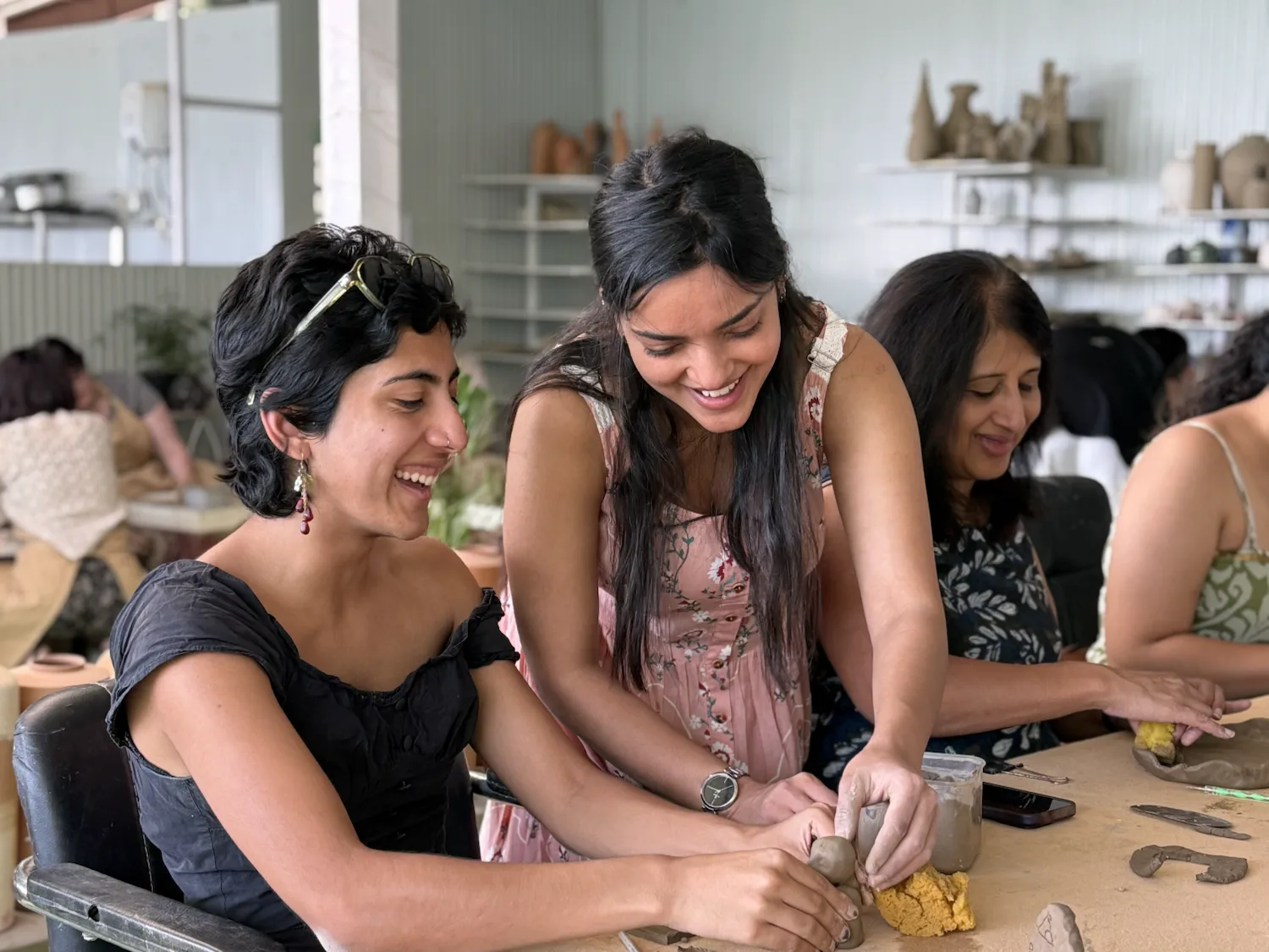 Participants handbuilding clay together during a private group pottery workshop at Dharamkot Studio in Himachal Pradesh.