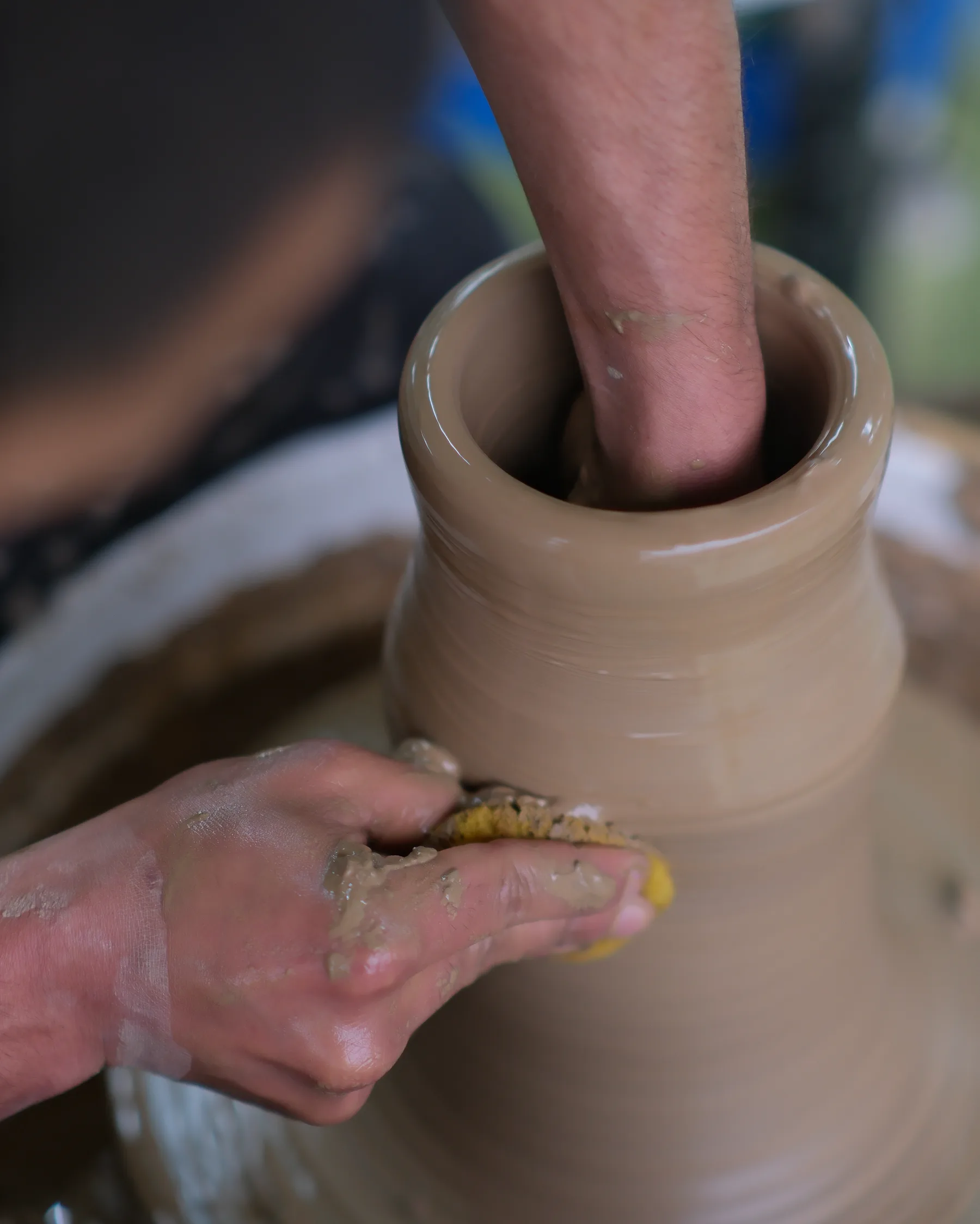Close-up of a clay vessel being shaped on the wheel during a Himachal pottery workshop.