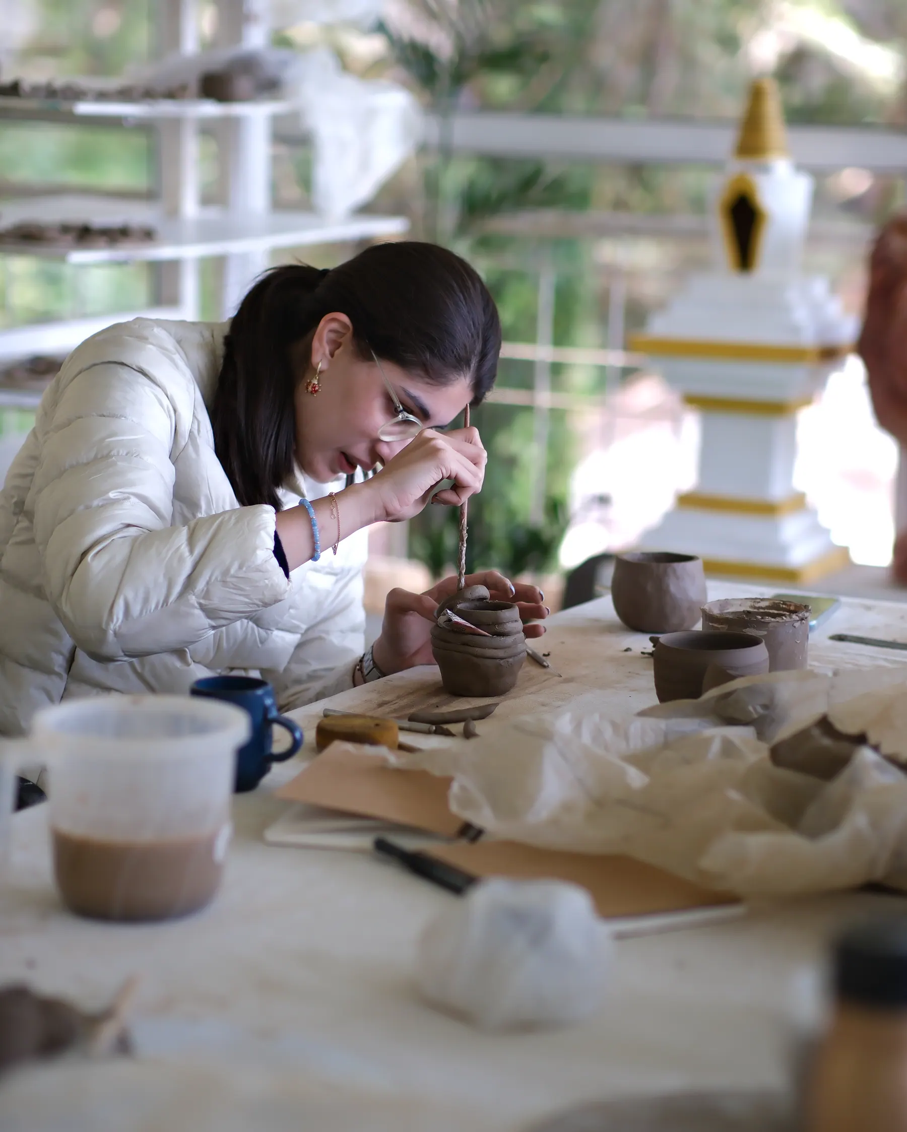 Participant refining a hand-built ceramic vessel during the Himachal Sculpt & Shape workshop.