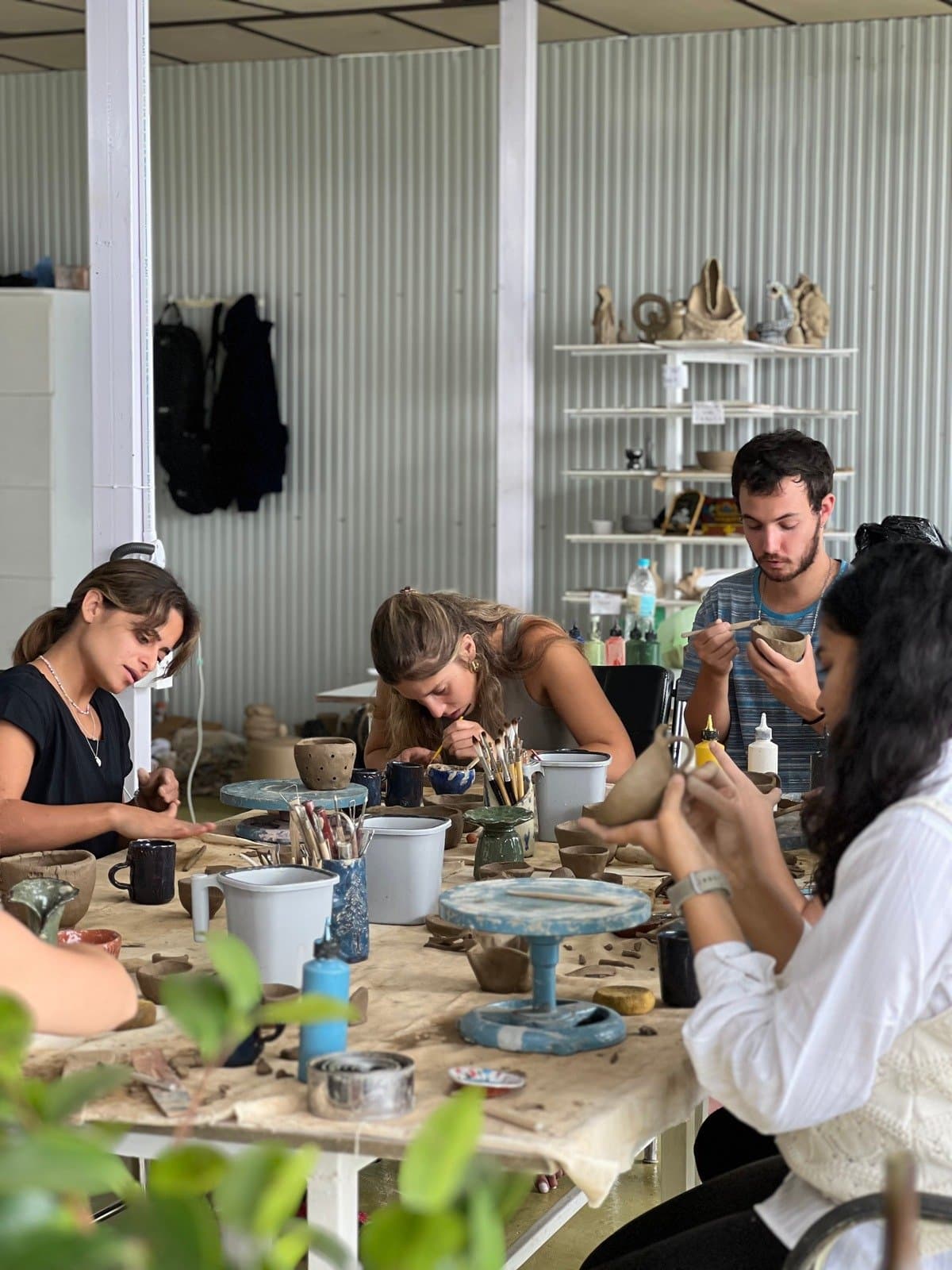 Residents engaging in hands-on clay practice at Dharamkot Studio.